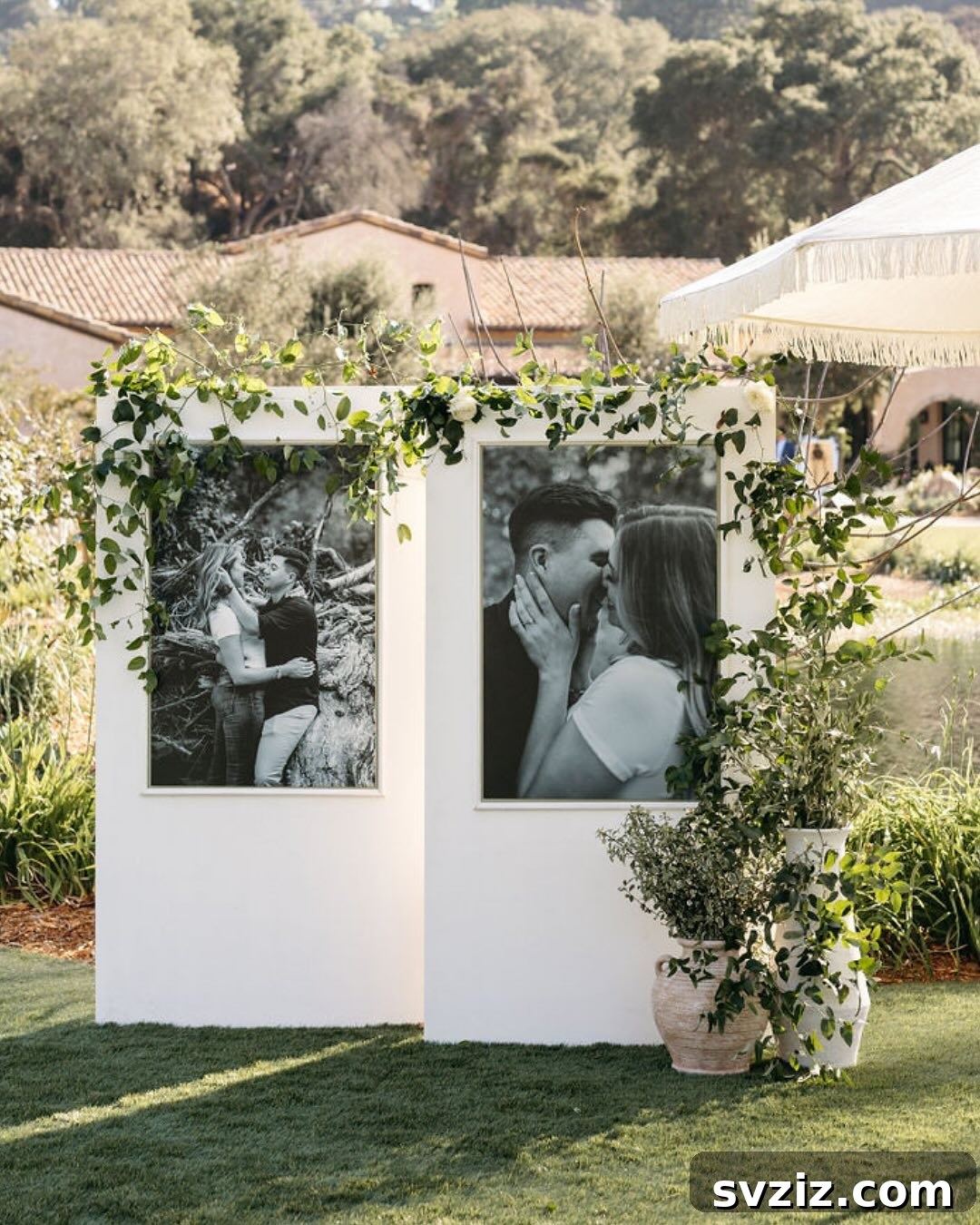 Large framed photos enhanced with cascading greenery on a wedding memory table.