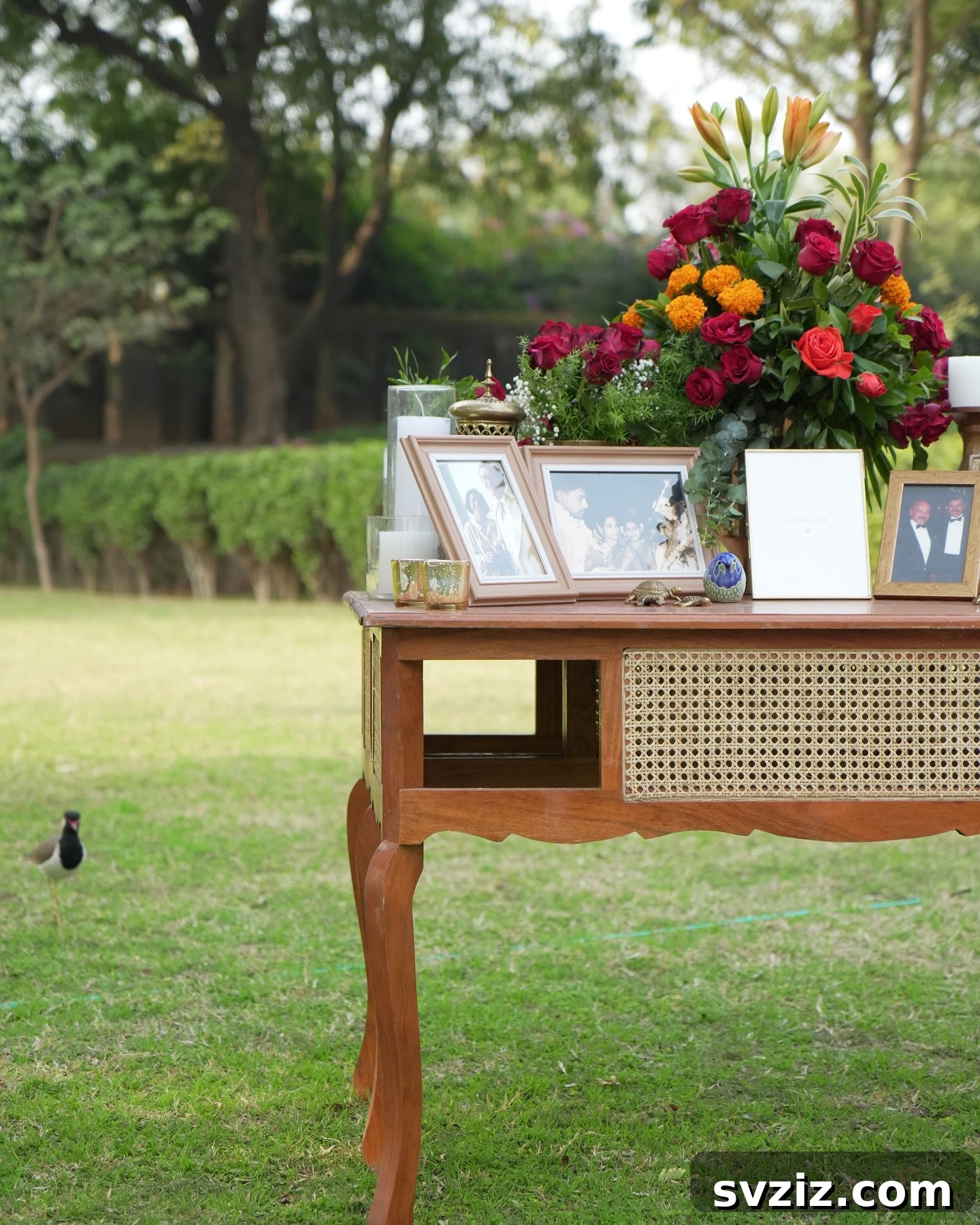 A tastefully decorated table showcasing photos of lost loved ones with matching wedding decor.