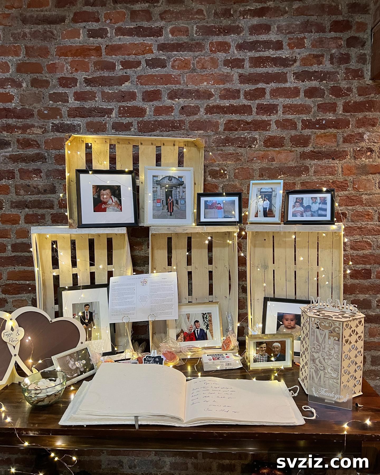 Rustic wedding memory table with decorative crates, photos, and space for guest interaction.