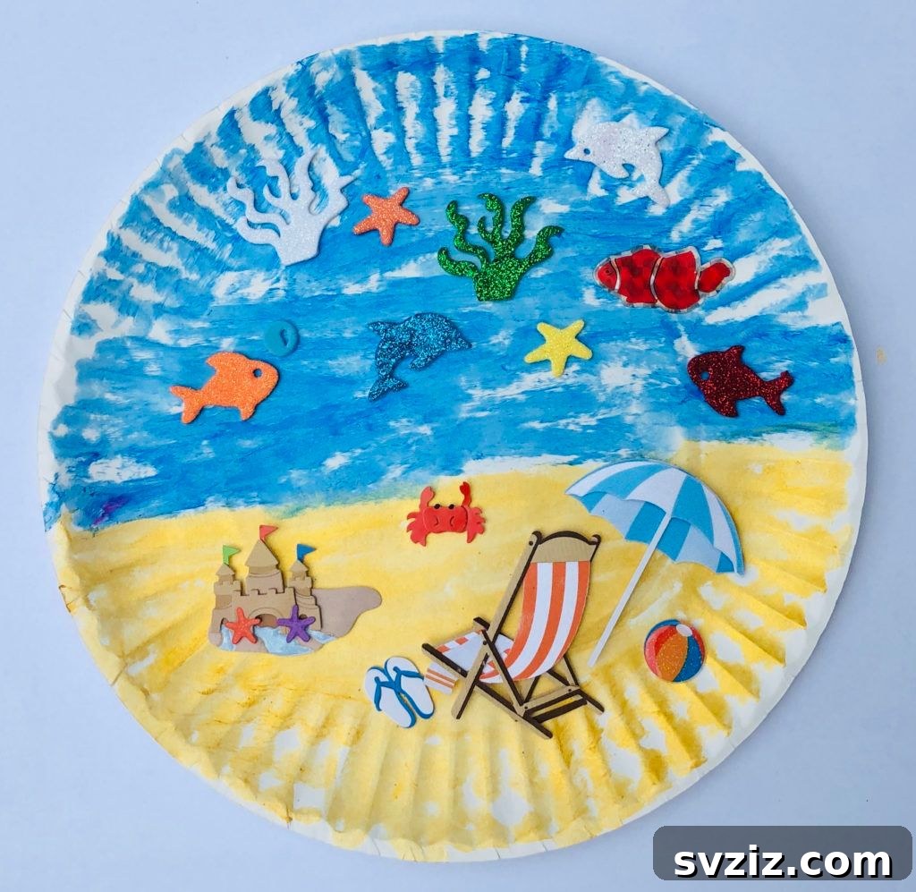 A vibrant paper plate beach craft featuring painted sand, blue ocean, a sunny sky, and charming fish stickers.