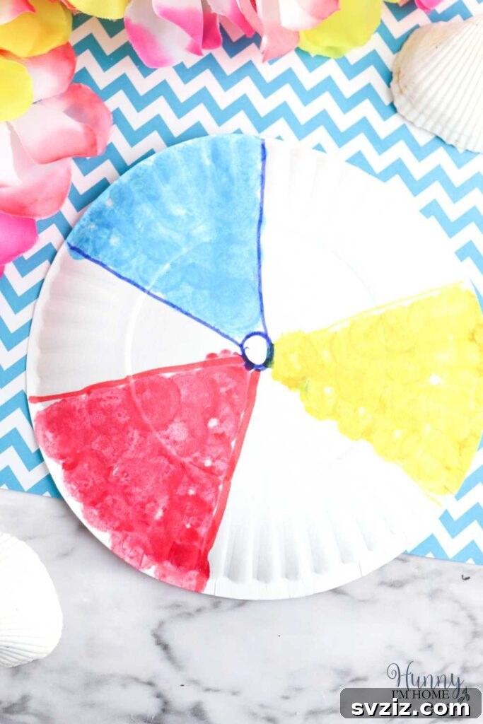 A simple and colorful paper plate beach ball craft, ideal for preschool-aged children to practice fine motor skills.