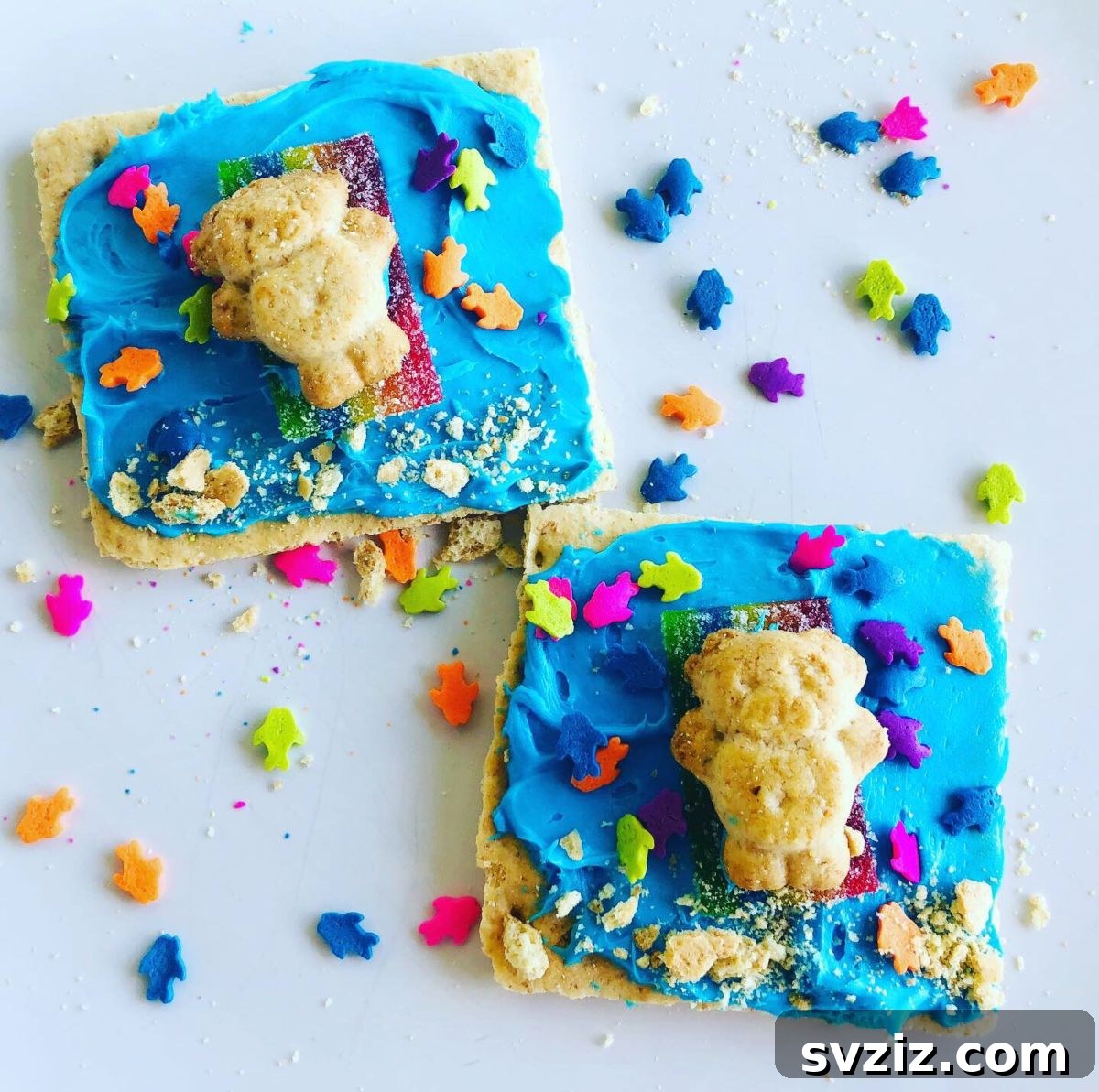 A creative beach snack craft featuring graham cracker 'sand,' blue frosting 'ocean,' teddy grahams 'bathers,' and colorful candy 'beach toys'.