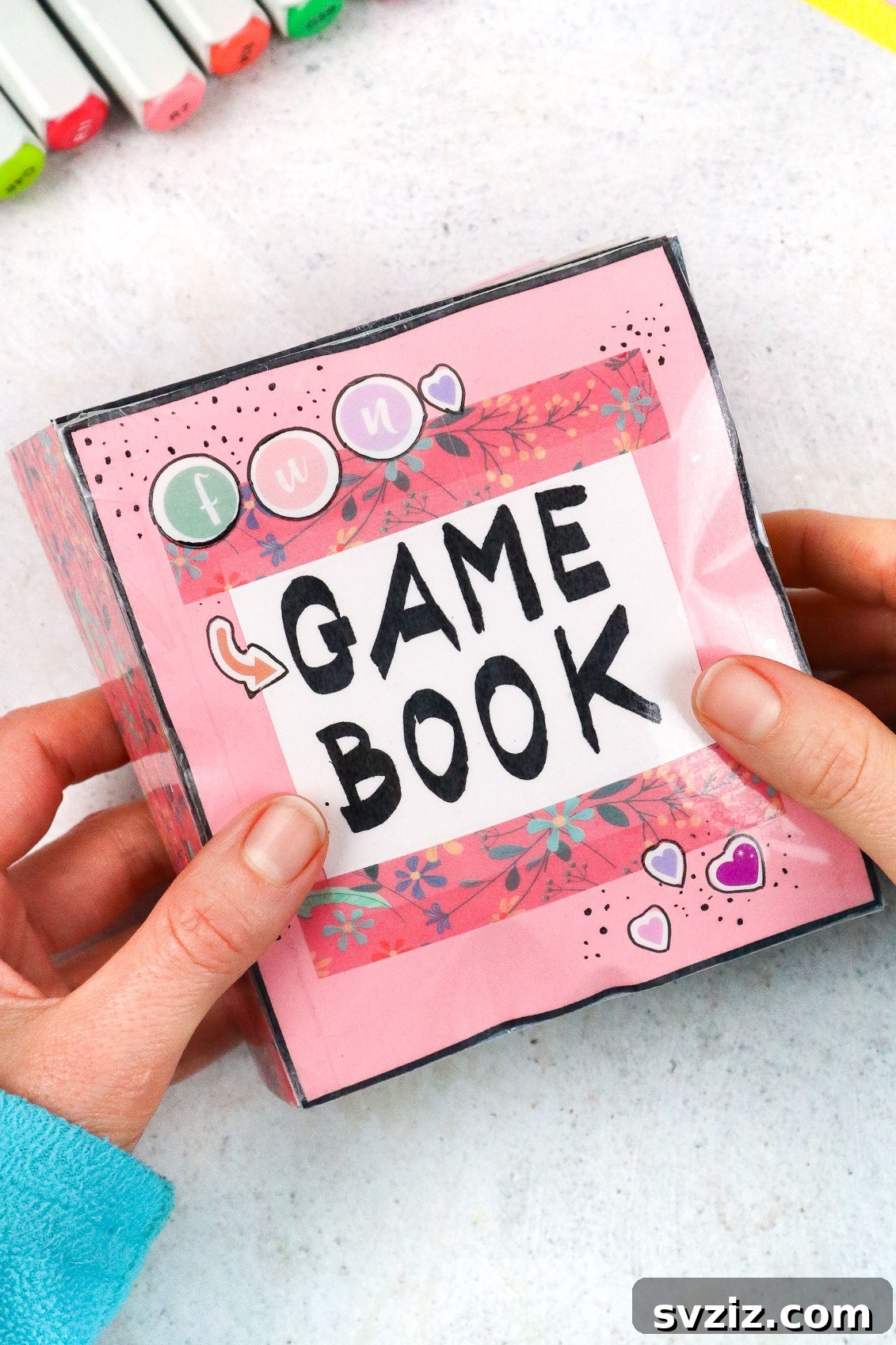 Open squishy game book with colorful, textured pages.