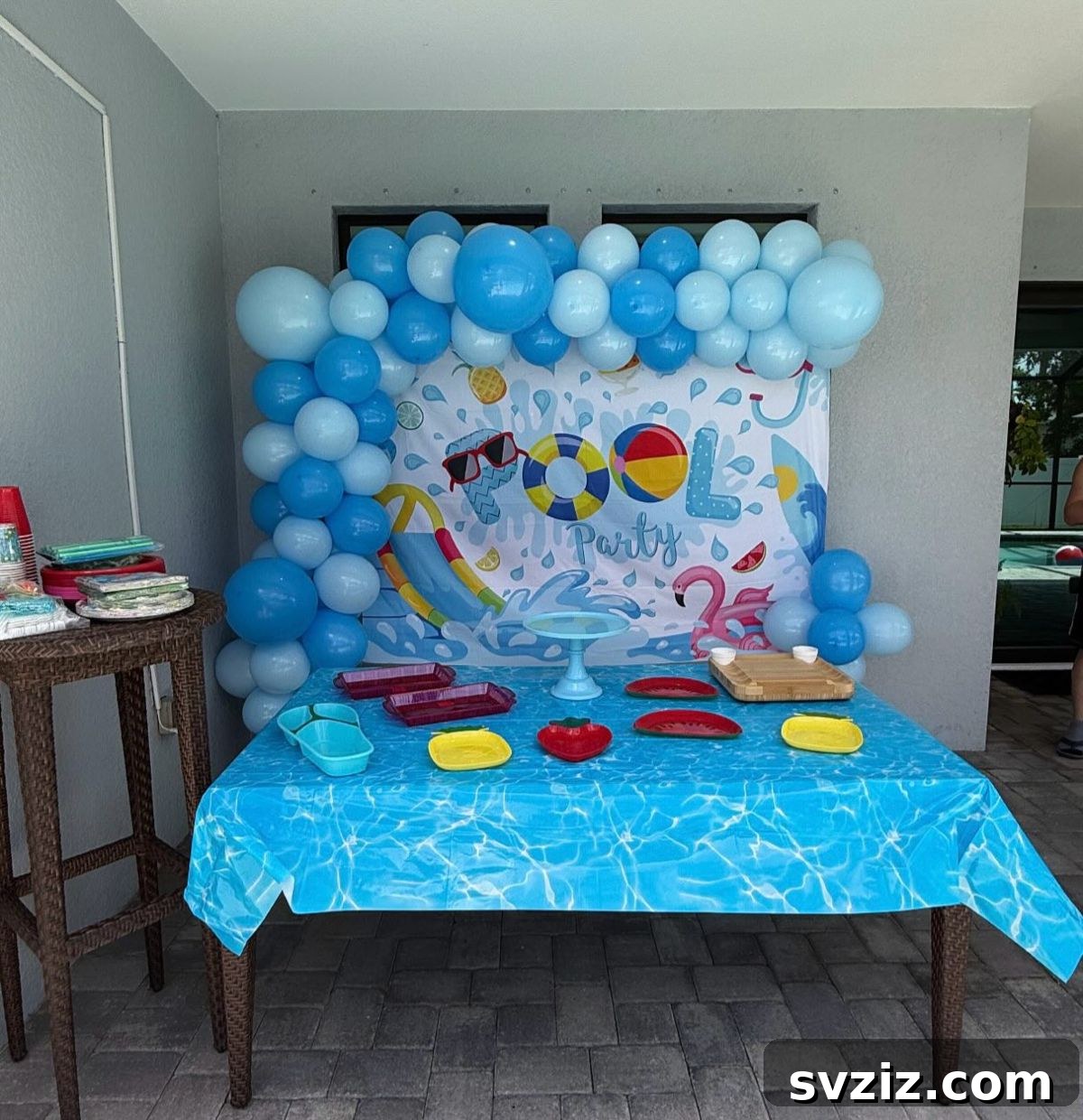 Splash into Summer: Creative Pool Party Ideas 20 Blue-themed pool party decor with balloons and tablecloths.