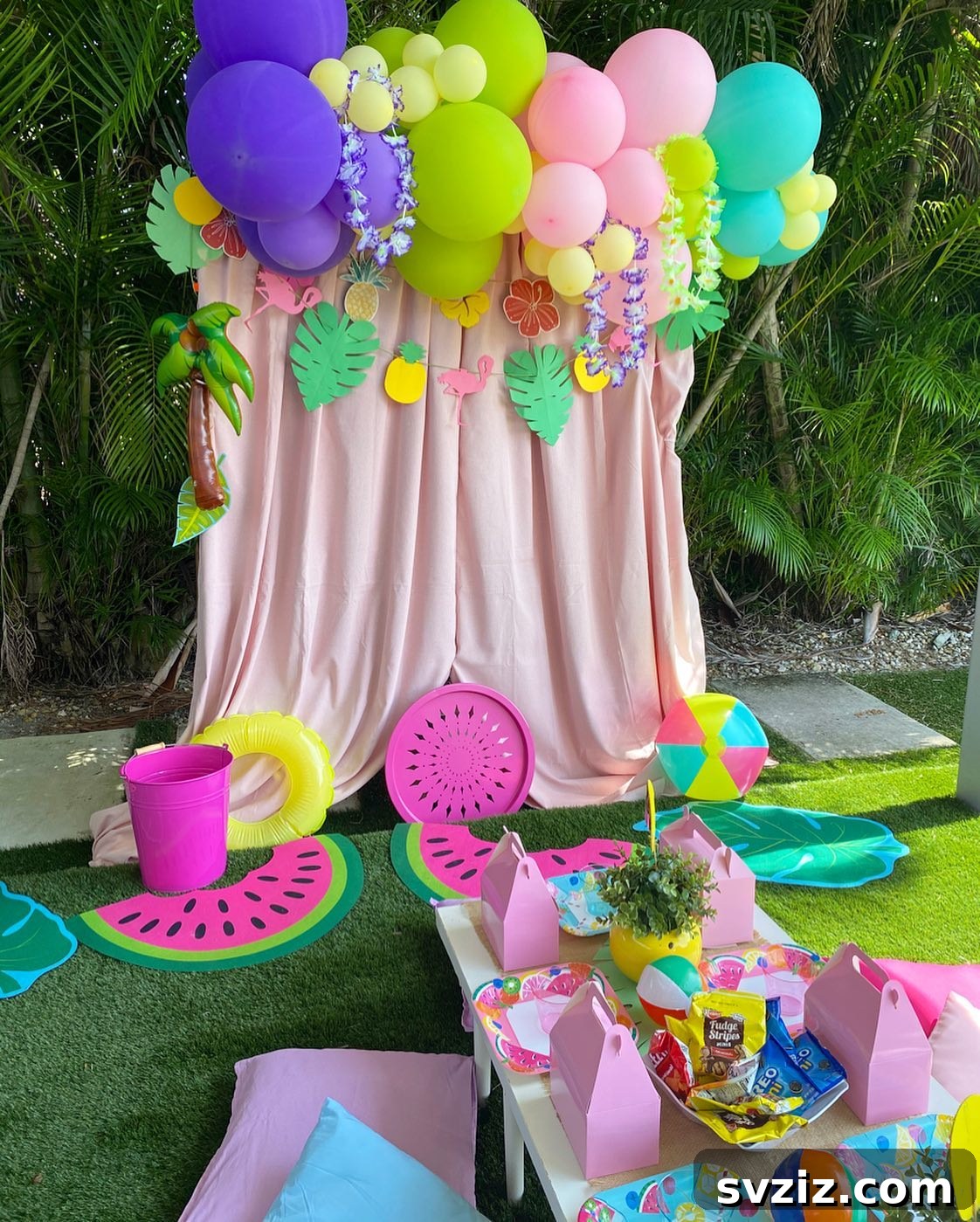 Splash into Summer: Creative Pool Party Ideas 25 Adorable pool party picnic setup with pink backdrop and tropical flowers.
