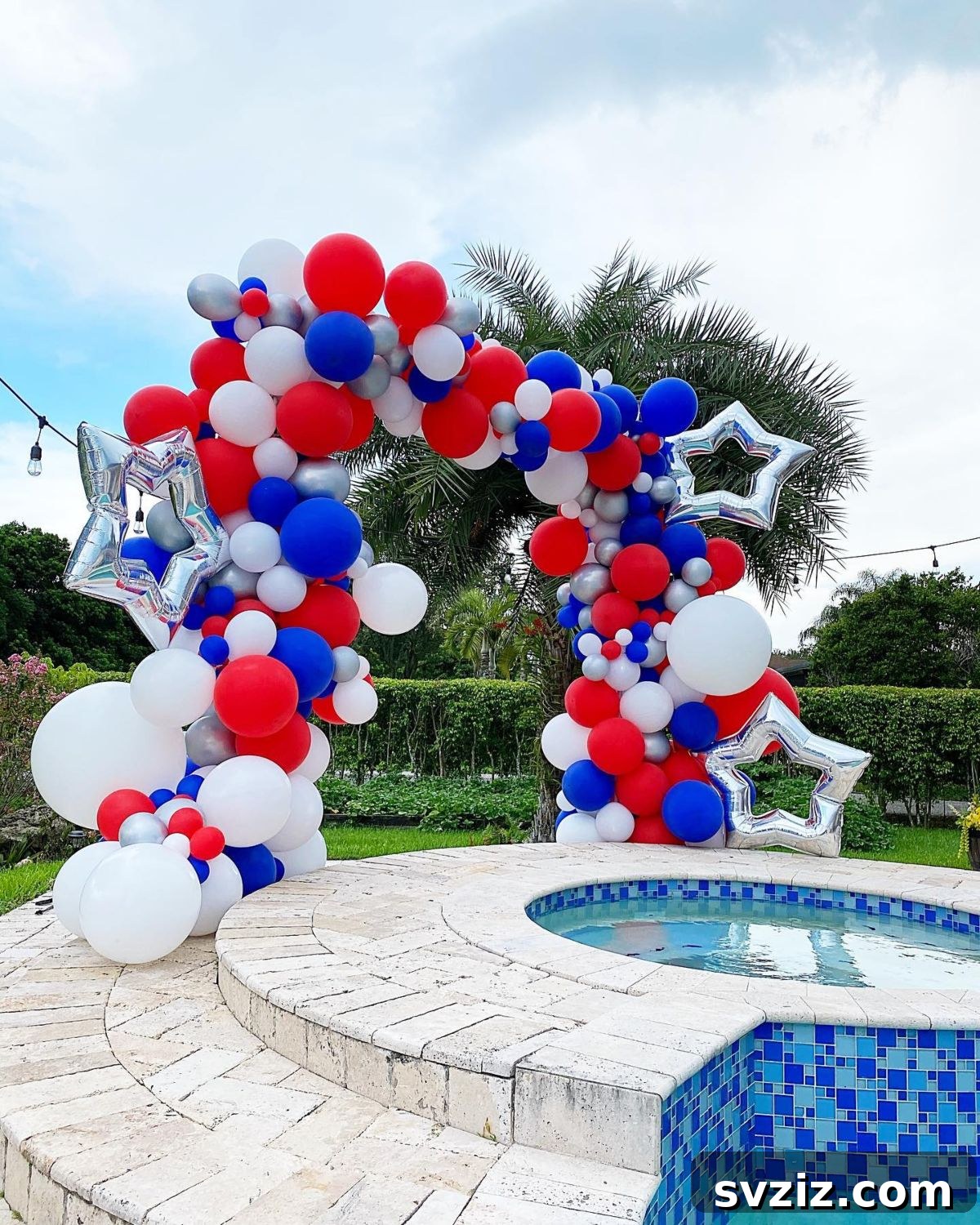 Grand patriotic balloon arch with red, white, and blue balloons and silver star accents.