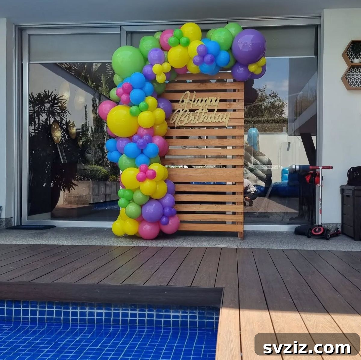 Colorful Happy Birthday balloon decor with festive accents for a joyful pool party.