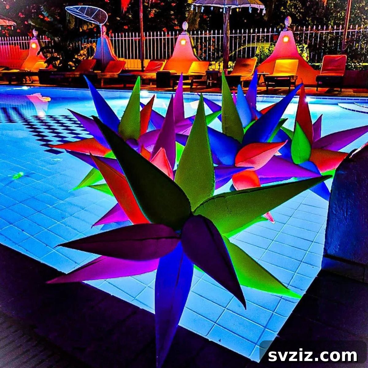Floating neon starburst balloons, perfect for an evening pool party's luminous decor.