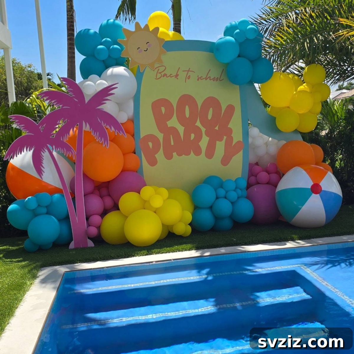 Vibrant tropical balloon arch with beach balls and palm trees for a summer pool party.