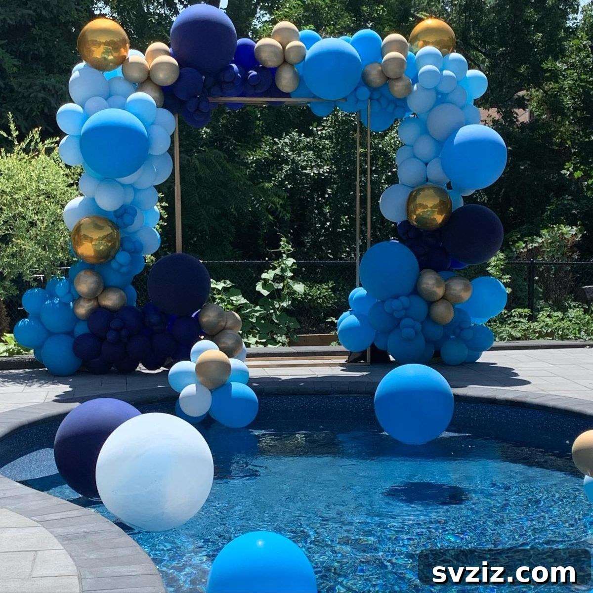Elegant blue balloon garland with touches of gold and silver for a chic pool party.