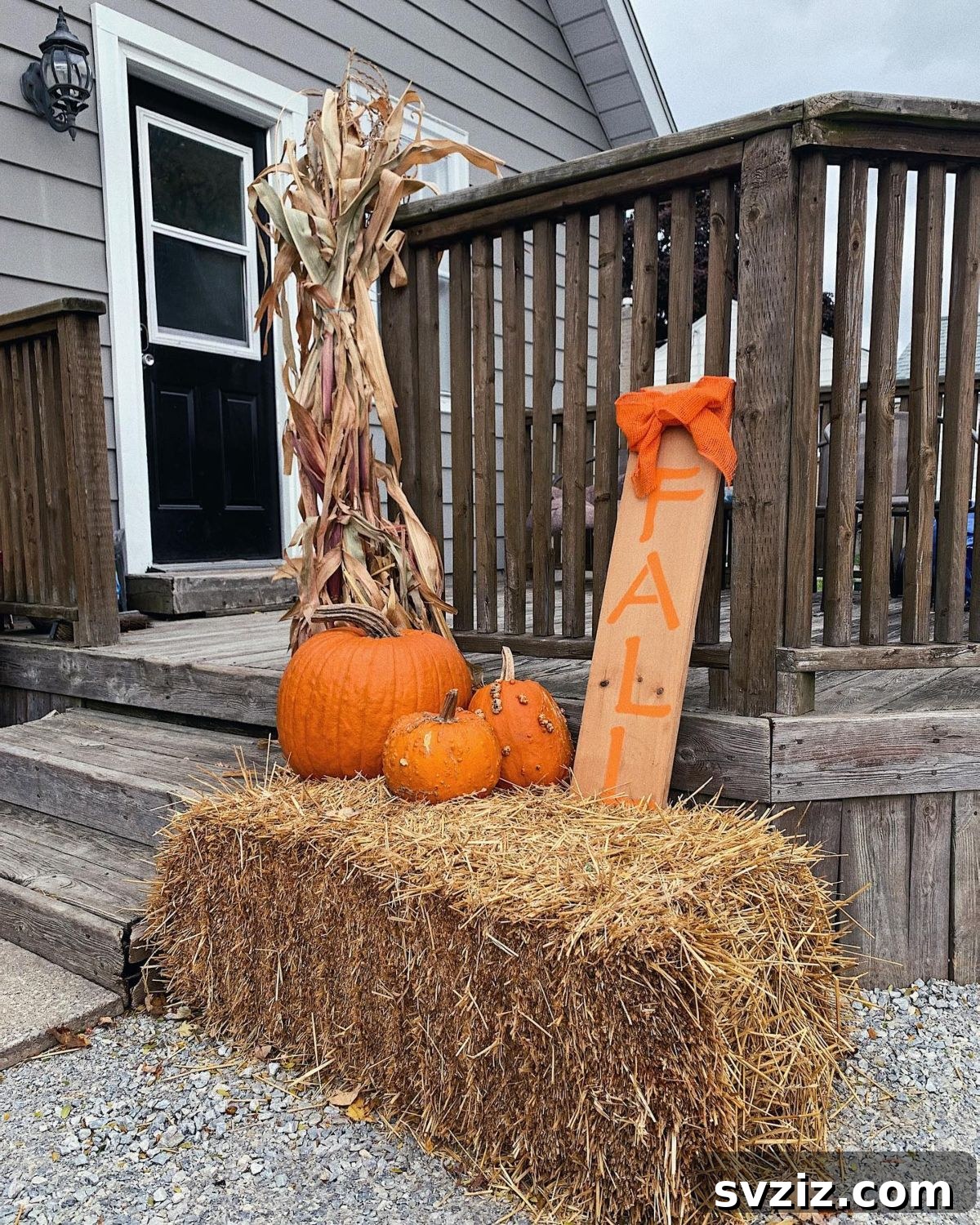 31 Autumn Outdoor Decor Ideas to Enhance Your Home's Curb Appeal 11 Fall decor featuring a hay bale adorned with a sweet orange bow and pumpkins
