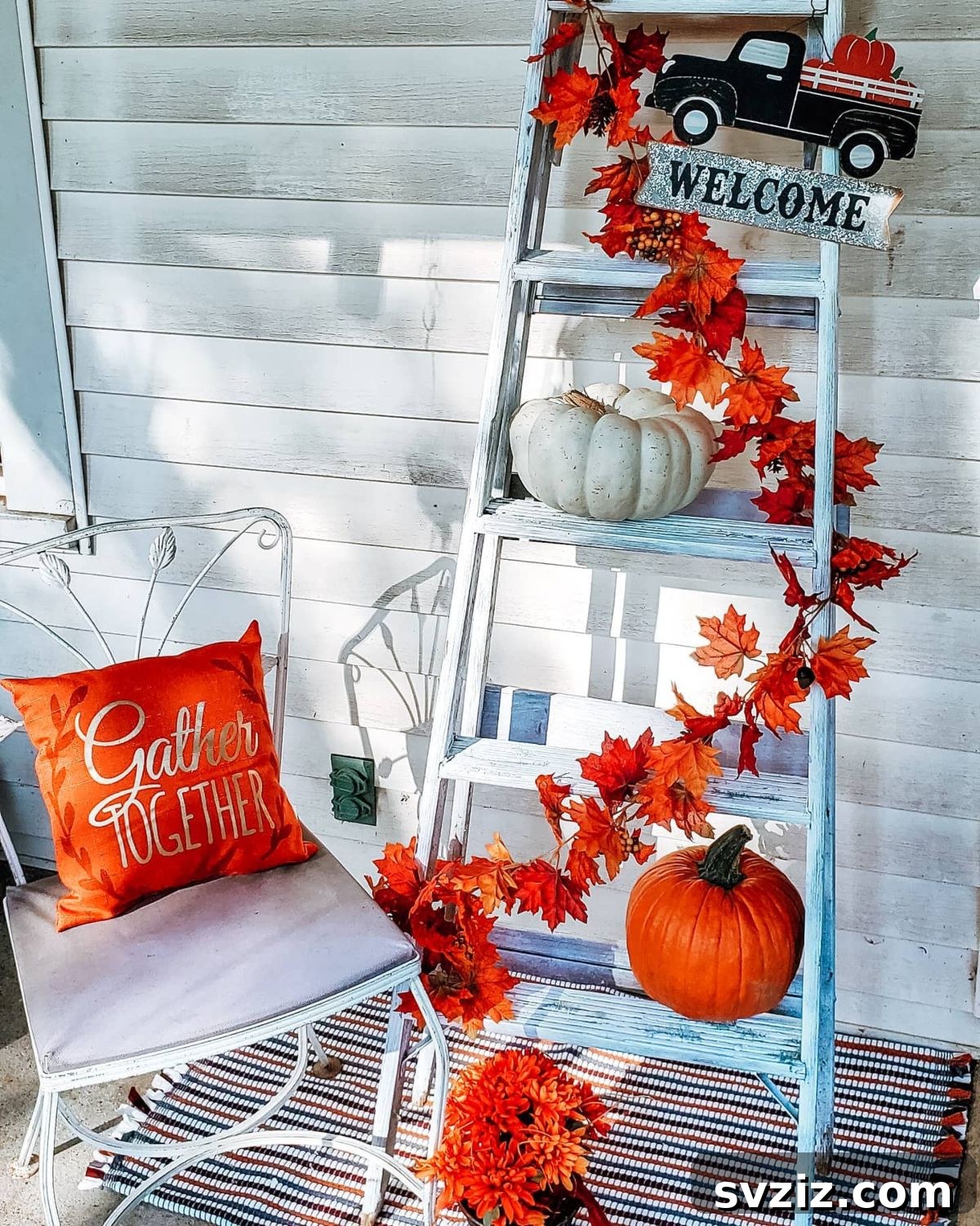 31 Autumn Outdoor Decor Ideas to Enhance Your Home's Curb Appeal 13 Fall welcome ladder decorated with vibrant orange pumpkins and a leafy garland