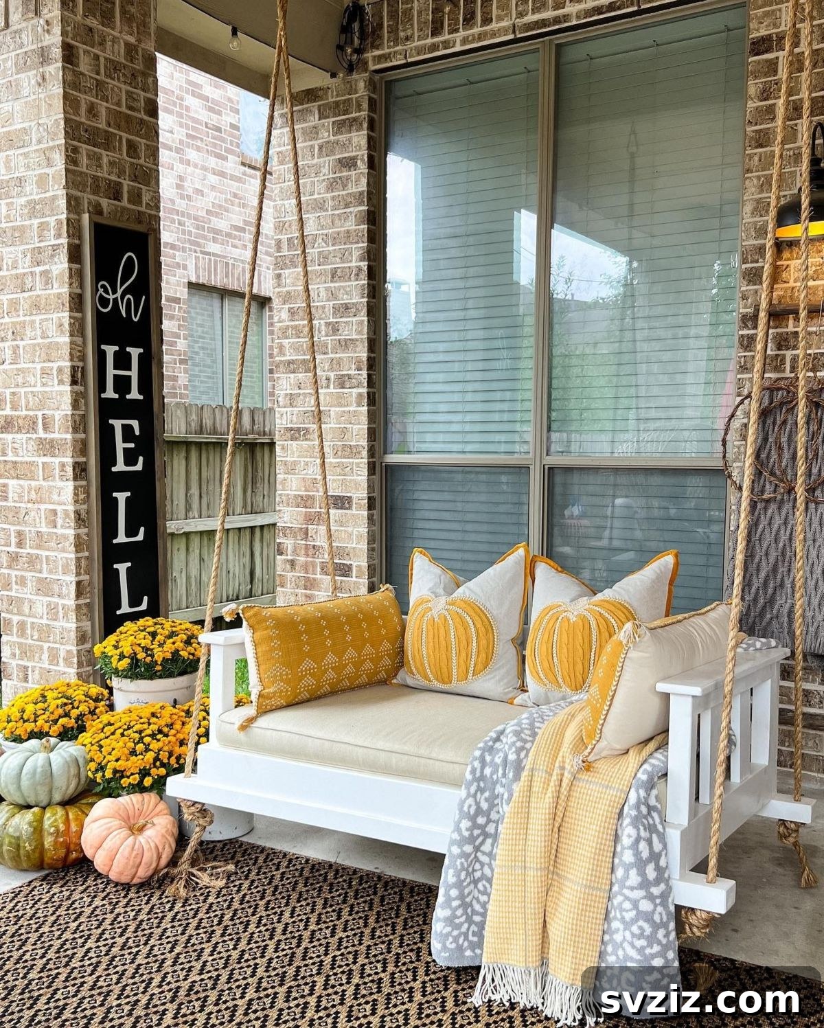 31 Autumn Outdoor Decor Ideas to Enhance Your Home's Curb Appeal 16 Fall-decorated porch swing with cozy throw pillows and seasonal accents