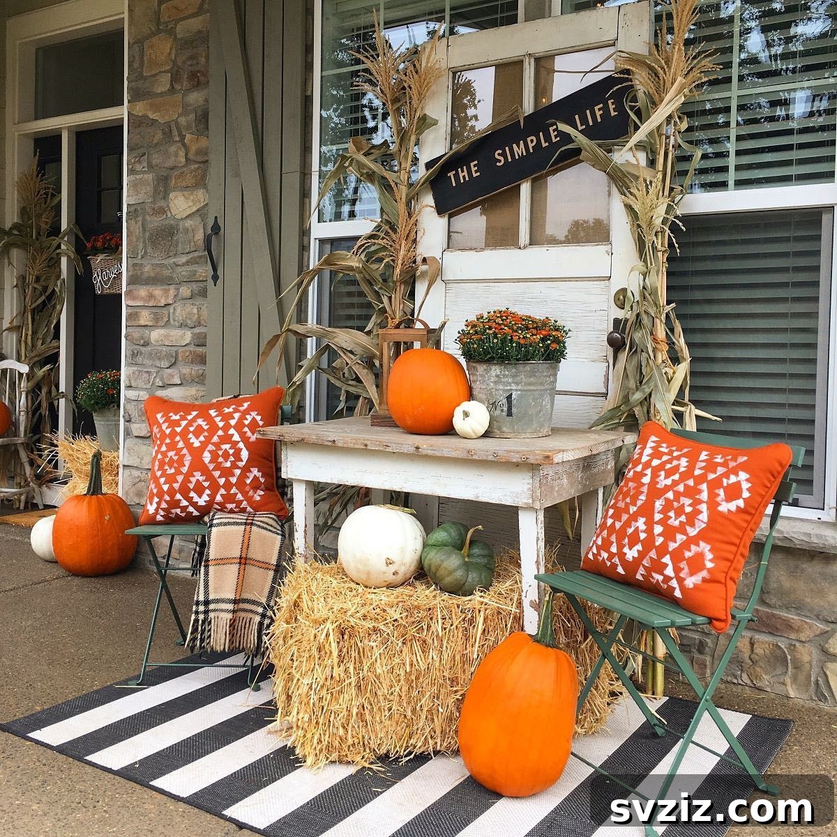 31 Autumn Outdoor Decor Ideas to Enhance Your Home's Curb Appeal 18 Cozy and rustic fall farmhouse porch with a small table, flowerpot, cushions, and pumpkins