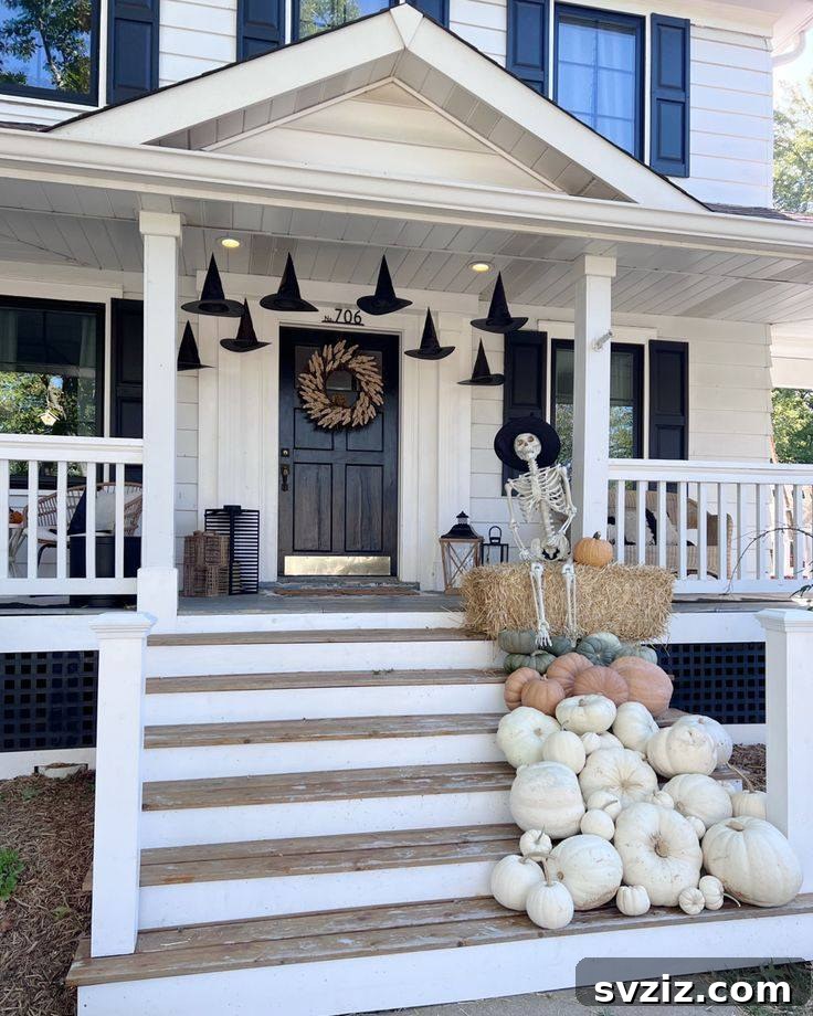 31 Autumn Outdoor Decor Ideas to Enhance Your Home's Curb Appeal 19 Spooky Halloween porch with a skeleton, hay bale, and hanging witch hats
