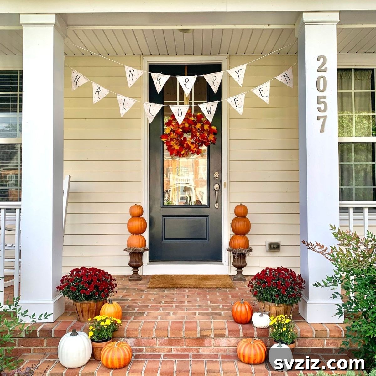 31 Autumn Outdoor Decor Ideas to Enhance Your Home's Curb Appeal 29 Simple yet beautifully arranged fall porch with pumpkins and a 'Happy Halloween' banner