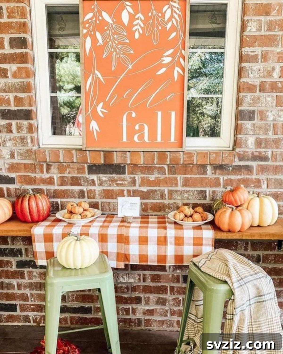 31 Autumn Outdoor Decor Ideas to Enhance Your Home's Curb Appeal 8 Cozy outdoor fall setup with orange pumpkins, checkered tablecloth, and 'Hello Fall' sign