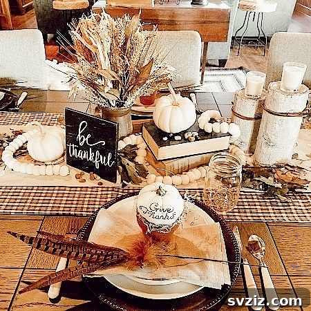 Craft the Perfect Feast: 21 DIY Thanksgiving Tablescapes 18 A cozy fall tablescape featuring a plaid table runner, white pumpkins, vintage books, and a 'be thankful' sign, exuding rustic charm.