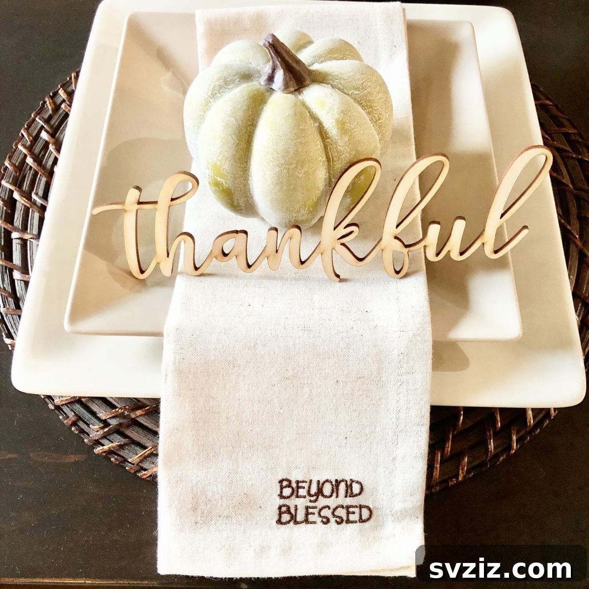 Craft the Perfect Feast: 21 DIY Thanksgiving Tablescapes 10 A minimalistic and sweet Thanksgiving centerpiece with wooden letters spelling 'Thankful' alongside a simple decorative pumpkin.