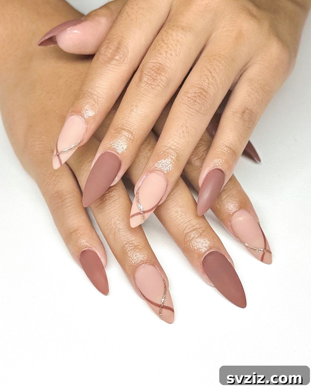 Chic Autumn Almond Nail Ideas 3 Minimalist brown and pink almond nails with delicate swirl accents, embodying modern fall elegance