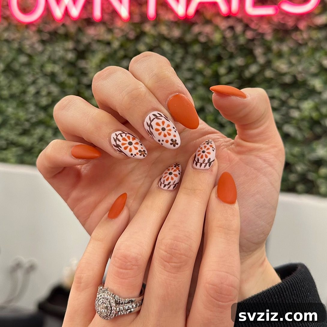 21 Exquisite Almond Nail Designs for Thanksgiving 20 18. Floral Designs on Orange Almond Nails for Thanksgiving