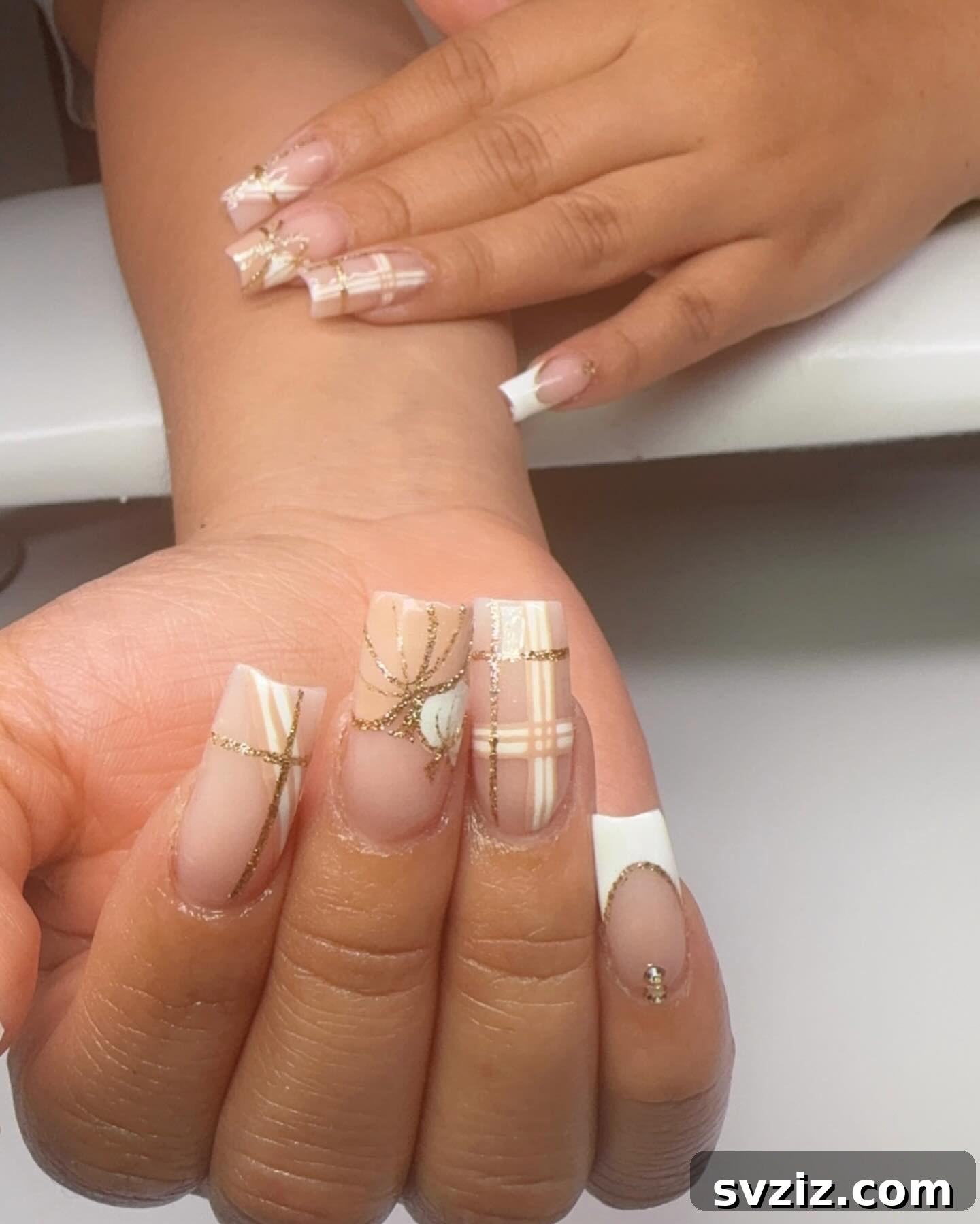 Stunning Thanksgiving Acrylic Nail Art for the Holiday Season 17 Elegant white and gold Thanksgiving acrylics featuring a chic white pumpkin design and a gorgeous plaid accent nail.