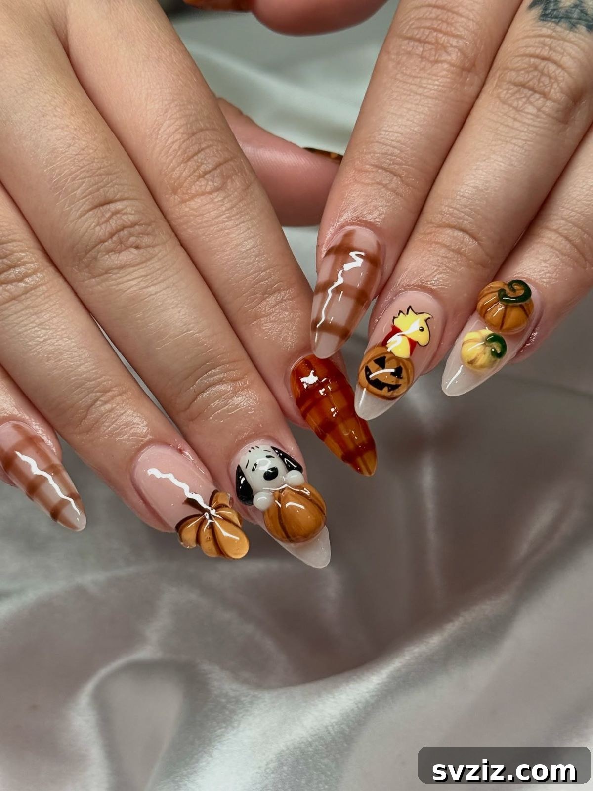 Stunning Thanksgiving Acrylic Nail Art for the Holiday Season 6 Playful Thanksgiving acrylic nails featuring festive pumpkins, sweet plaid accents, neutral tones, and a cute Snoopy character.