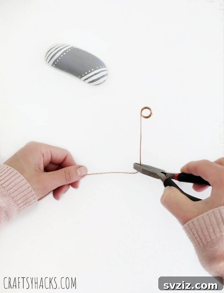 Needle nose pliers bending copper wire into a 90-degree angle