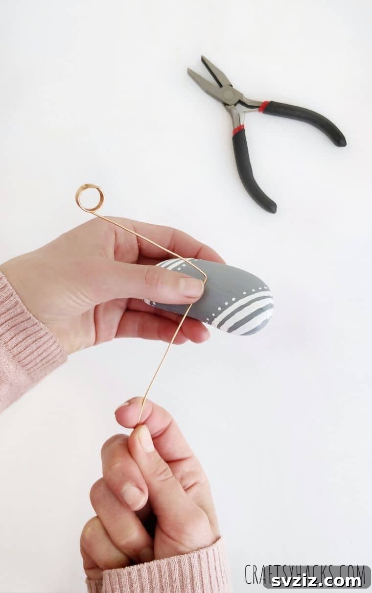 Copper wire being wrapped around a decorated rock
