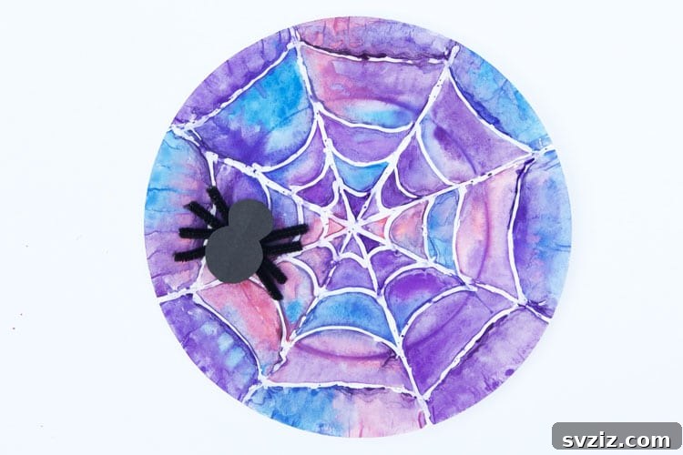 Spin a Web of Wonder: Spider Crafts for Your Little Bug Enthusiast 18 A beautiful watercolor spider web art project on a paper plate, outlined with hot glue.