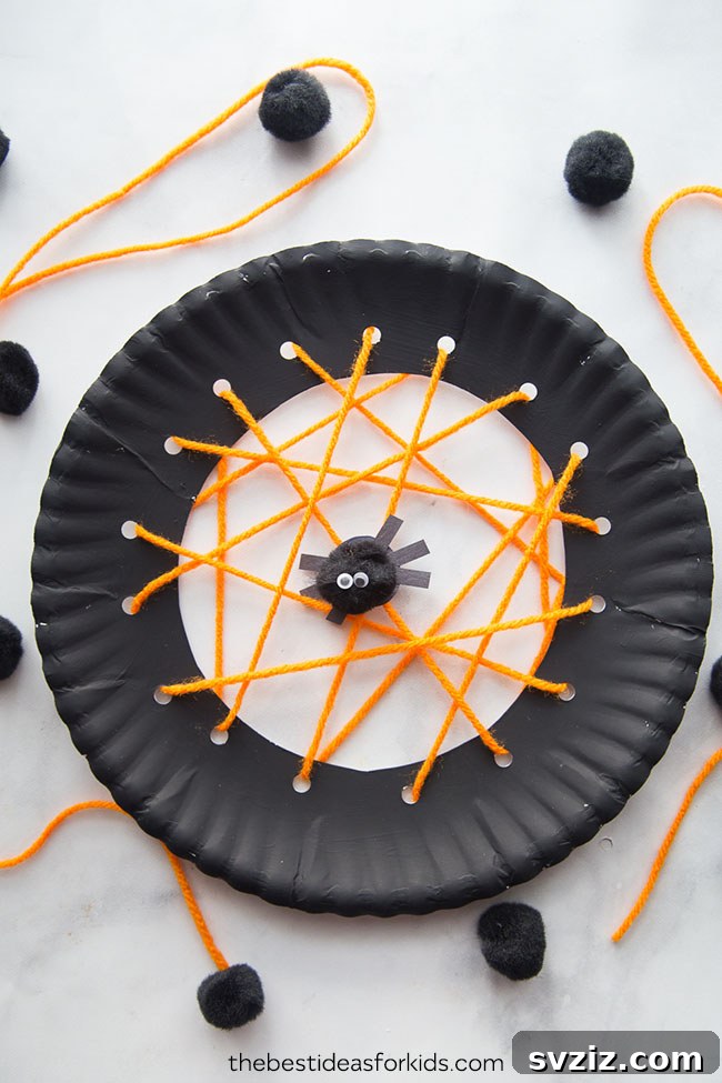 Spin a Web of Wonder: Spider Crafts for Your Little Bug Enthusiast 24 A vibrant woven spiderweb craft made from a paper plate and yarn, featuring a small black spider.