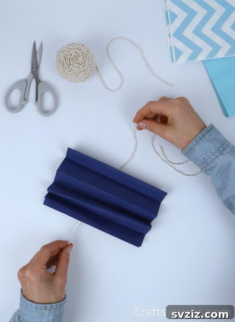 wrapping string around folded tissue paper