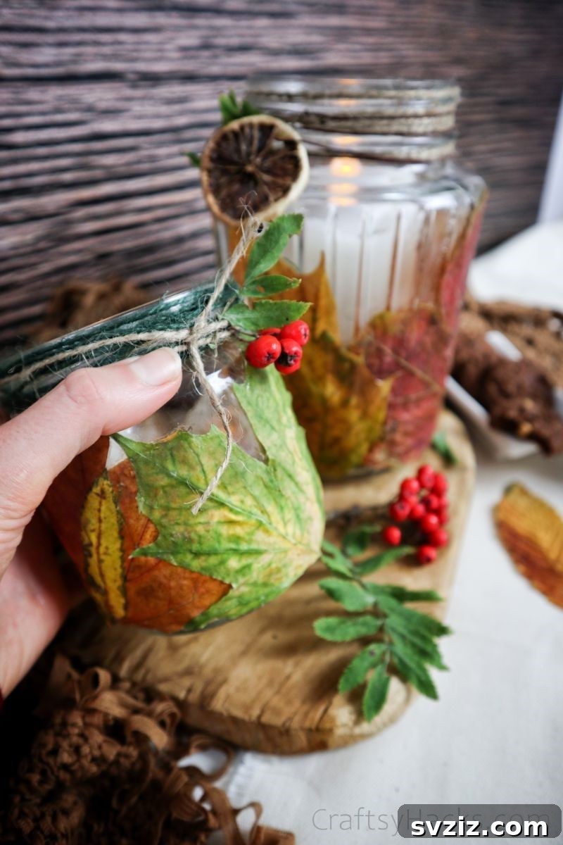 A hand presenting a finished DIY leaf candle holder, emphasizing its simple elegance and autumnal charm.