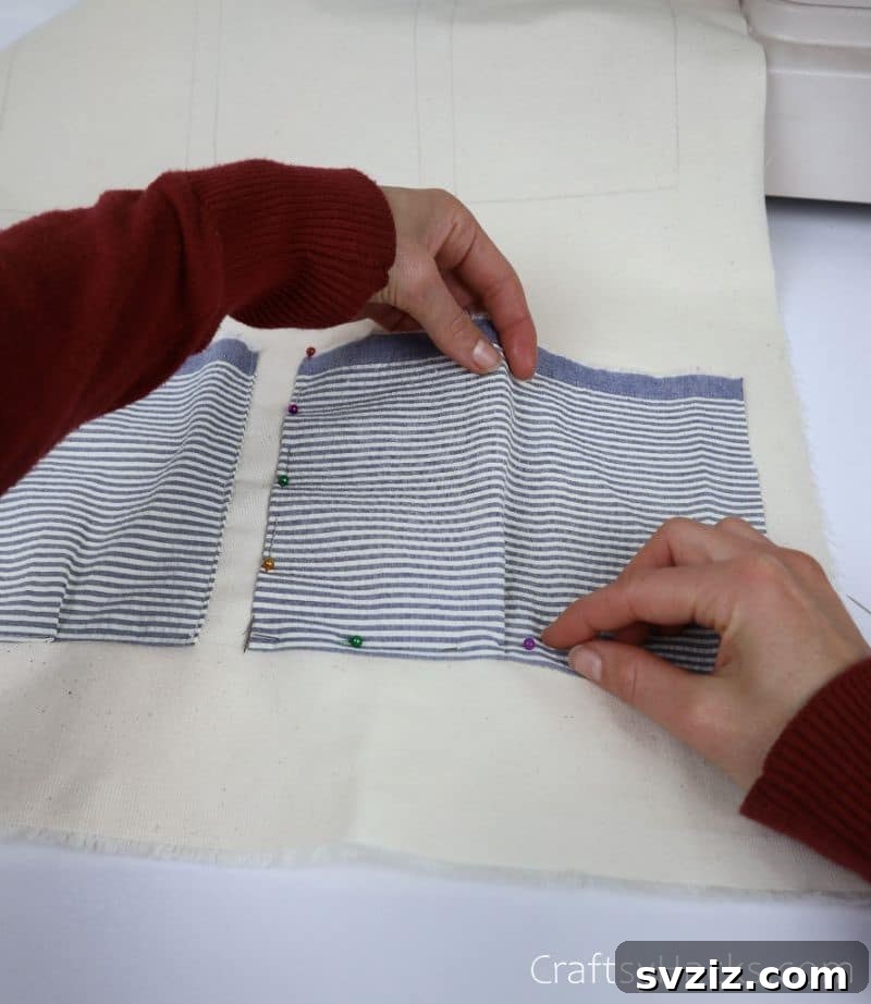 Detailed view of pinning the hem on a fabric pocket piece