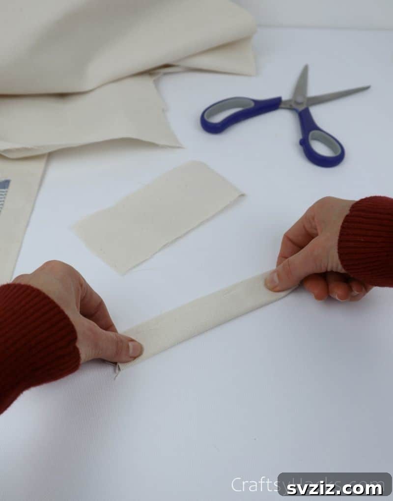 A fabric rectangle folded neatly in half and pinned, forming a loop