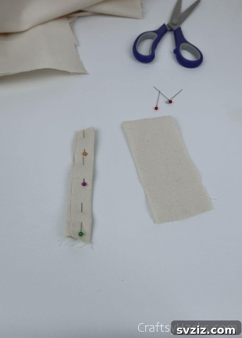 Pins holding folded fabric strips in place before sewing