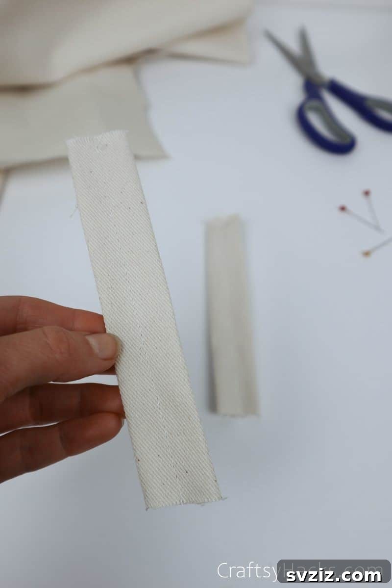 A sewn, folded fabric strip, ready to be attached as a loop