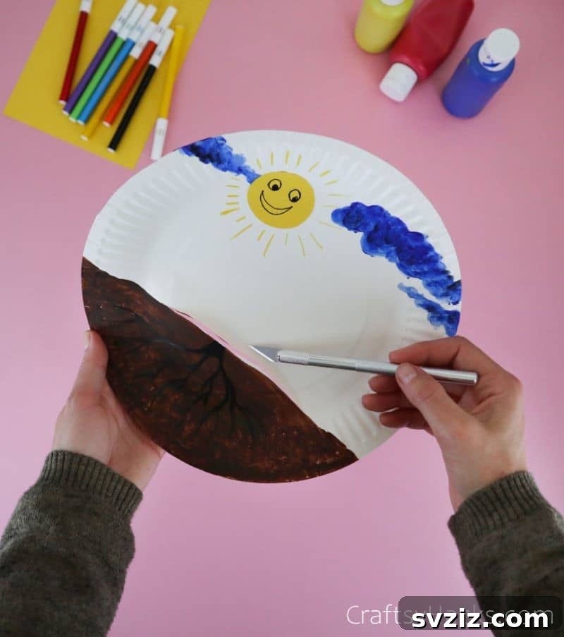 cutting a hole in paper plate for craft stick
