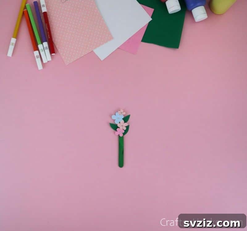 completed popsicle stick flower attached to stem