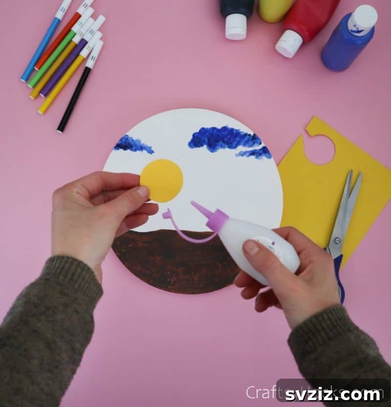 gluing sun onto paper plate craft