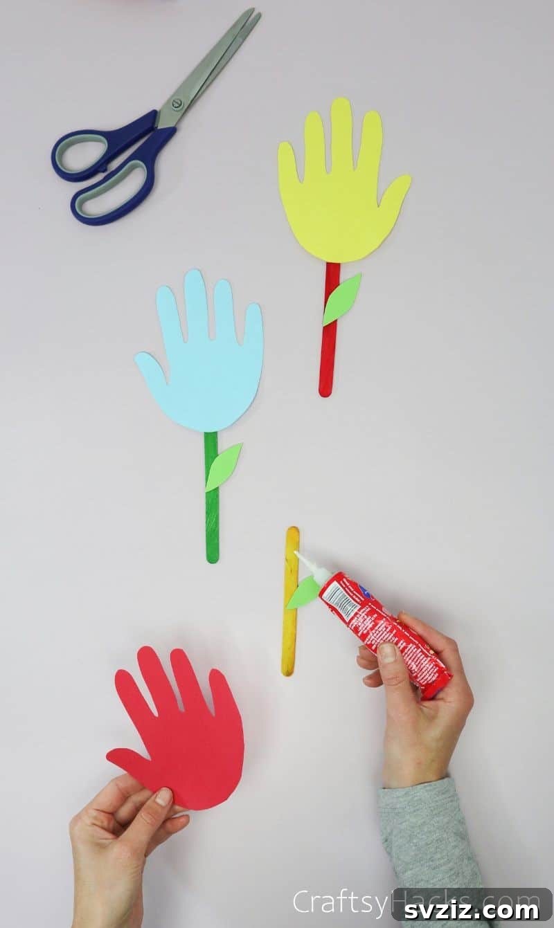 glueing handprints to popsicle sticks
