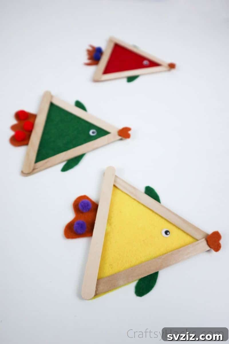 Simple Fish Crafts Kids Love to Make at School 15 Three completed fish crafts in different colors, showcasing various decorative elements.