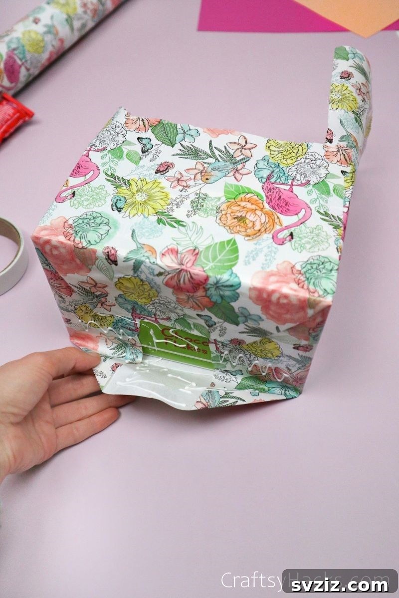Securing wrapping paper with glue on the DIY desk organizer for a neat finish