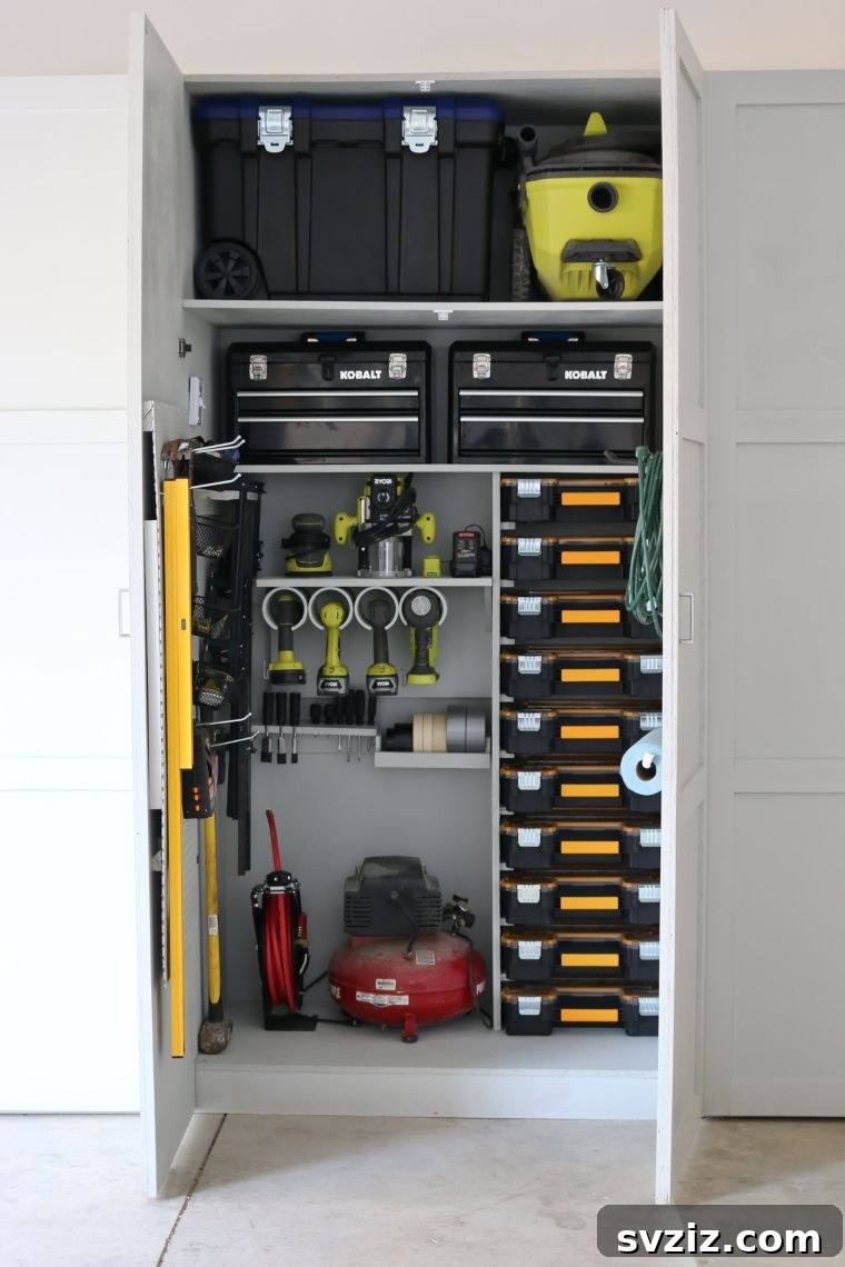 Workshop cabinet with organized tools inside, including PVC pipe holders for drills