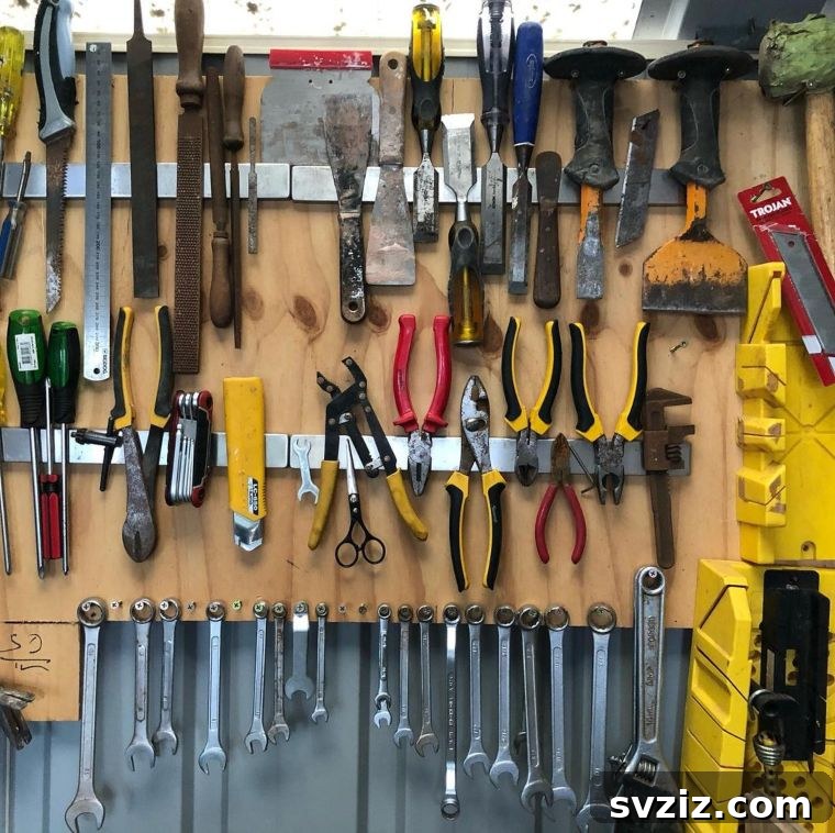 Magnetic strips holding various metal hand tools on a workshop wall