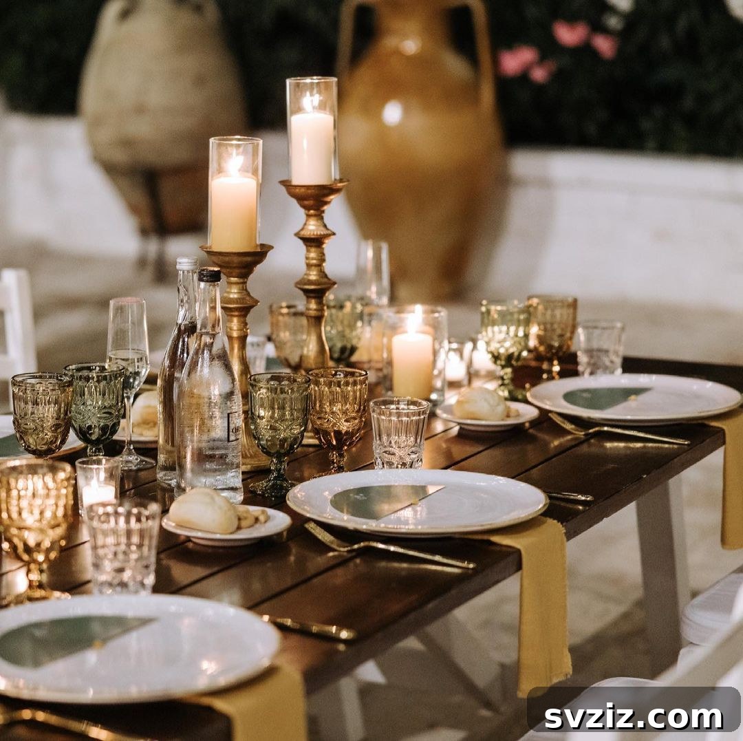 Vintage wedding table decor featuring sage green, ochre, ornate candle holders, and windblown glassware.