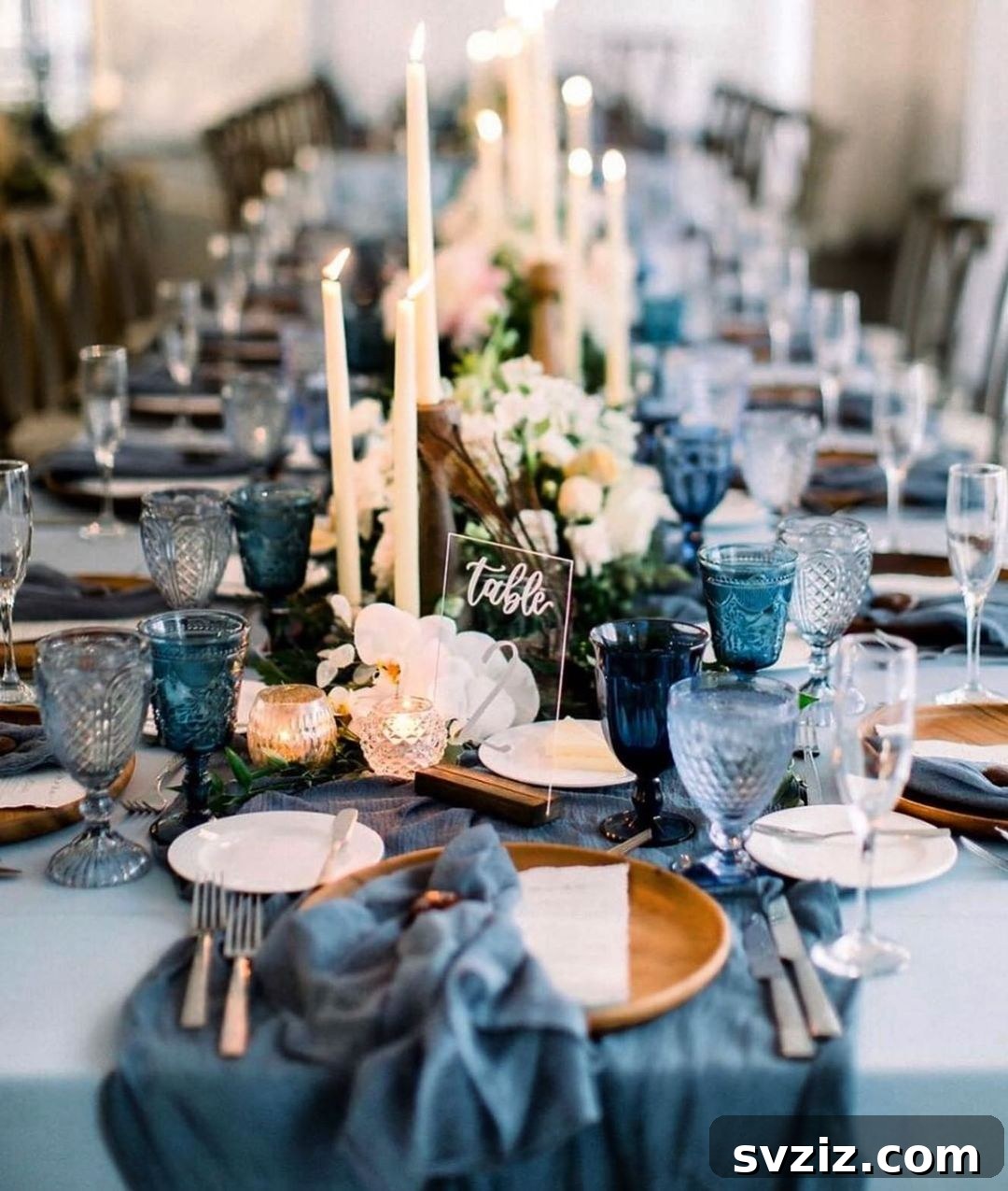 Blue-themed wedding table with gauzy cheesecloth runner, blue sea-glass goblets, reminiscent of blue skies and waters.