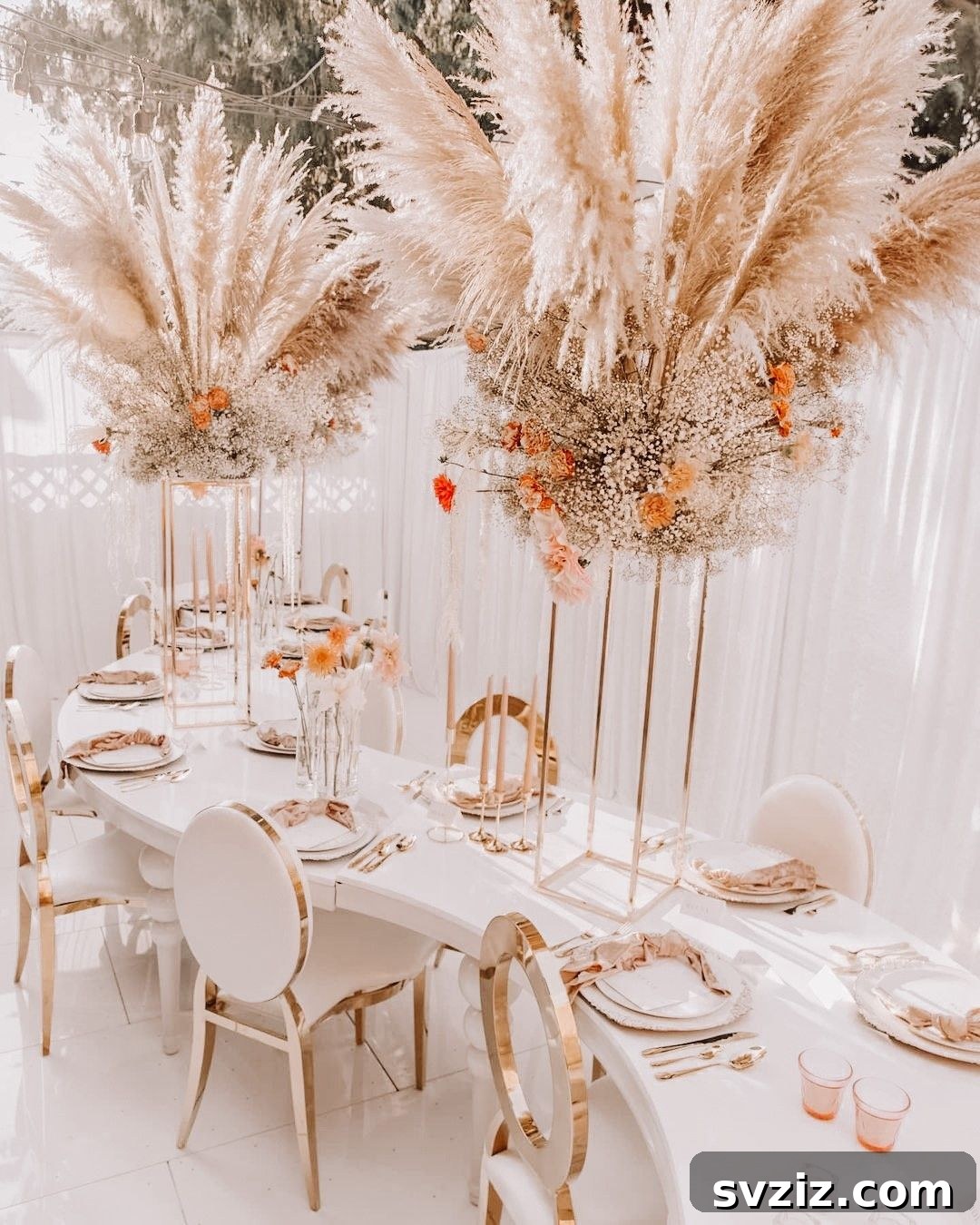 Fairytale Bohemian Wedding Decor with a towering floral centerpiece featuring baby's breath, orange gerberas, and pampas grass.