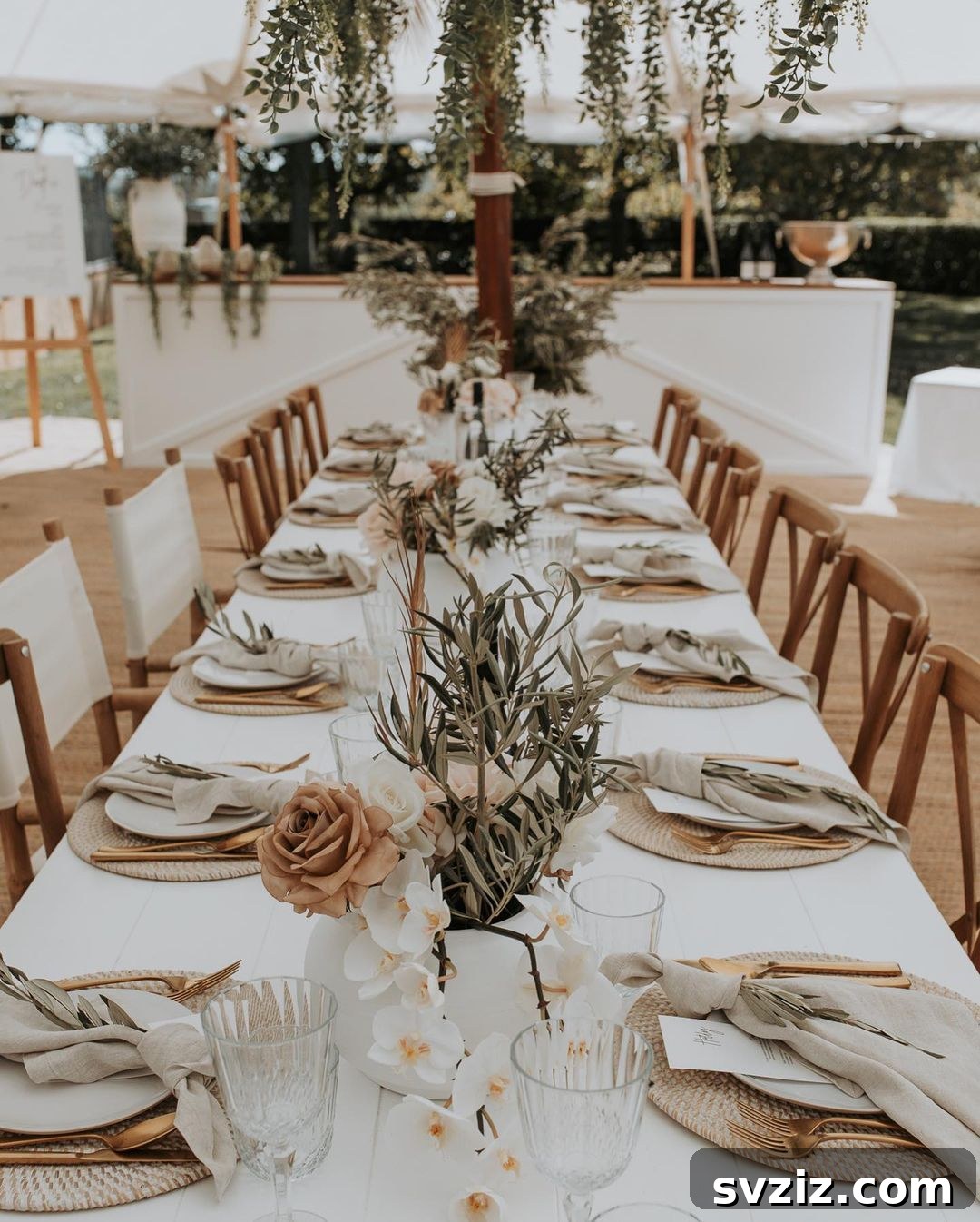 Mellow Bohemian Wedding Decor with white cherry blossoms, blush roses, olive leaf vines, and sage green dinnerware.