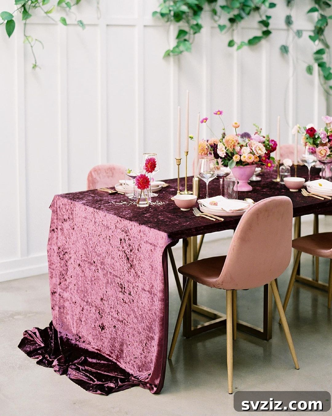 Alice in Wonderland-inspired wedding table with quirky decor, flowers, and a luxurious burgundy velvet tablecloth.